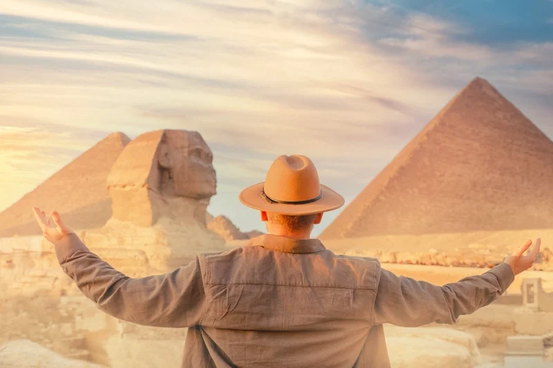 Uomo in una foto panoramica tra Sfinge e Piramidi durante il tour di 7 giorni al Cairo con crociera sul Nilo