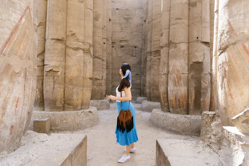 Turista tra i colonnati di un antico tempio egizio