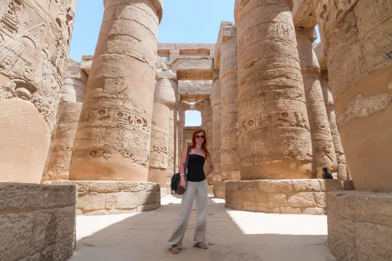 Turista tra i colonnati di un tempio egizione durante il tour Cairo, crociera 5 stelle e Berenice