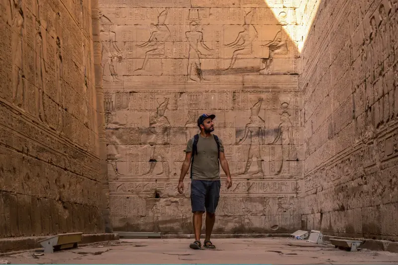 Turista che osserva i gerogligici egizi durante il tour Egitto tra Cairo, Berenice e crociera 5 stelle