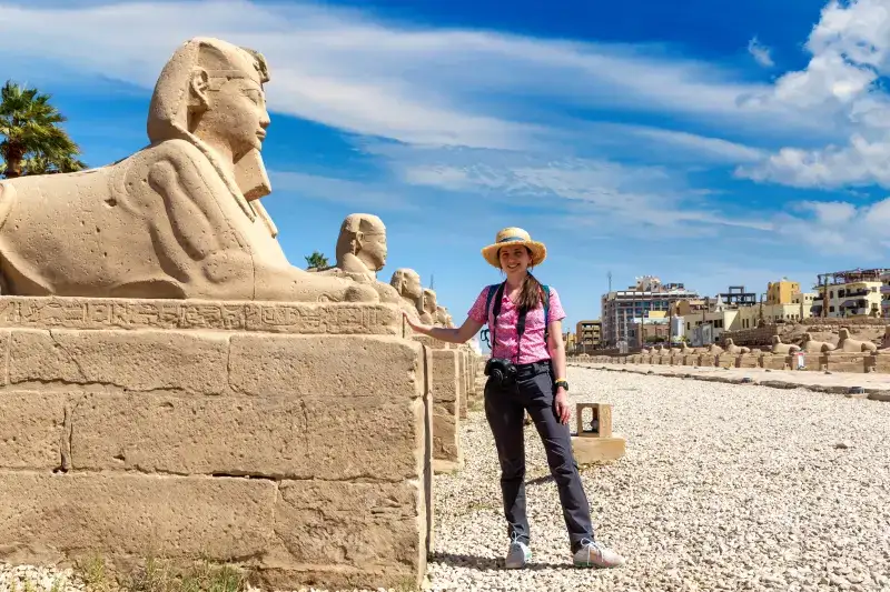 Visitatrice con statue egizie nella città di Luxor