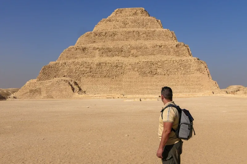 Uomo che osserva la piramide a scaloni