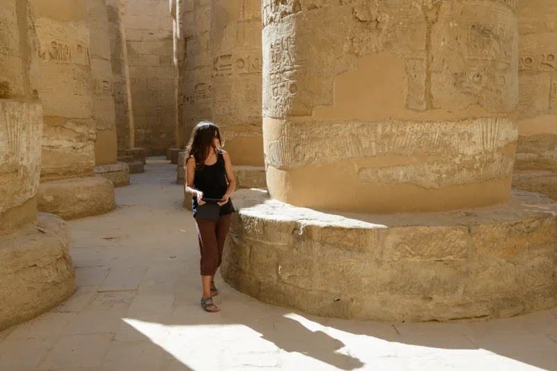 Turista a passaggio tra i colonnati di un tempio egizio