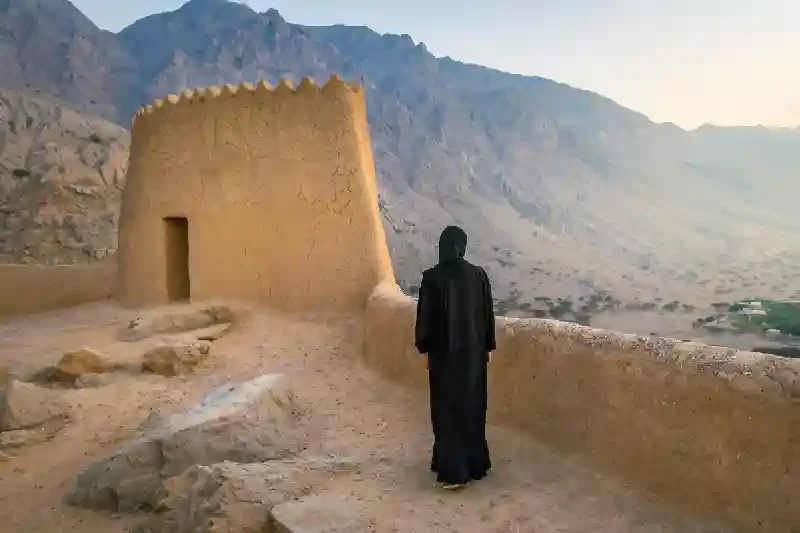 Donna di fronte a una struttura antica emiratina con il viaggio di Ferragosto a Dubai