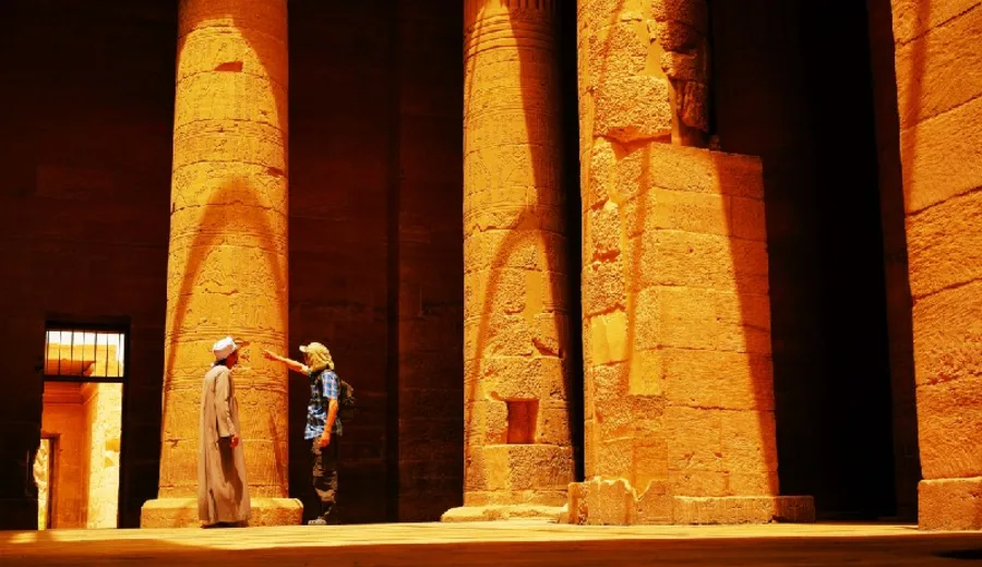 una Turista Explorando los jeroglíficos en las Columnas de un Antiguo Templo Egipcio.