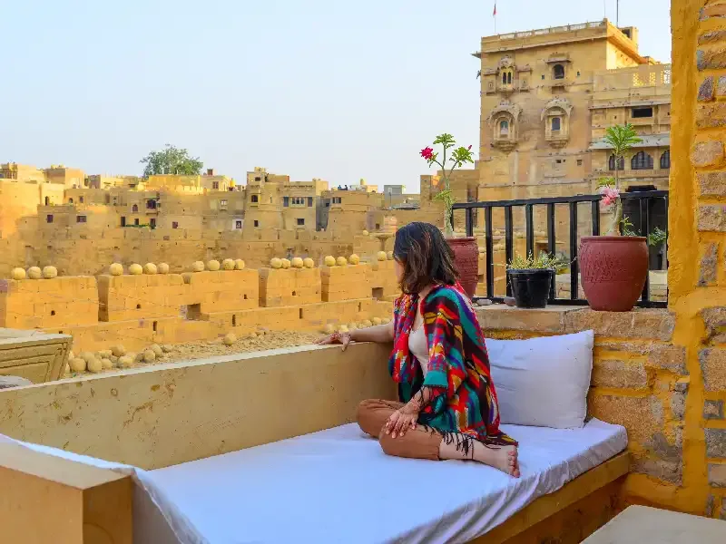 Ragazza che si affaccia dalla balconata di una casa tradizionale indiana