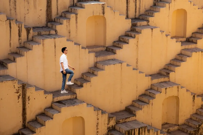 Uomo che cammina su una struttura coperta di scale in totale serenità, l'articolo fa riferimento alle assicurazioni e ai documenti utili per l'India