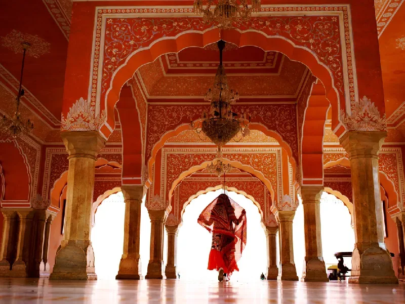 Donna che cammina sotto le arcate del Palazzo di Jaipur, struttura tra le cose da vedere in India