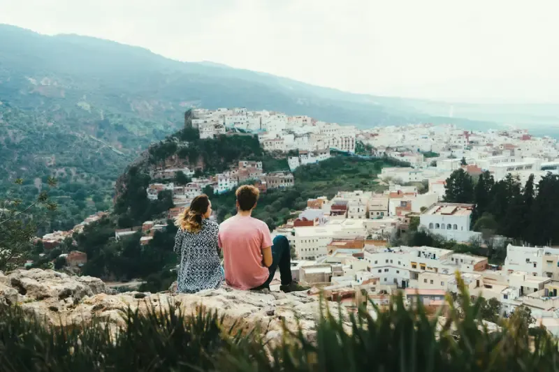 una coppia che guardano la vista panoramica di Moulay Idriss Zerhoun, Marocoo in inverno