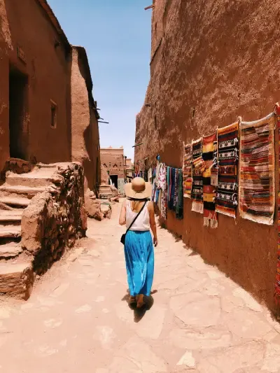 Una donna camminando lungo le strette vie del villaggio di Ait Ben Haddou in Marocco, Marocco in inverno