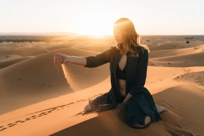 Donna seduta sulla sabbia nel deserto, Dubai deserto