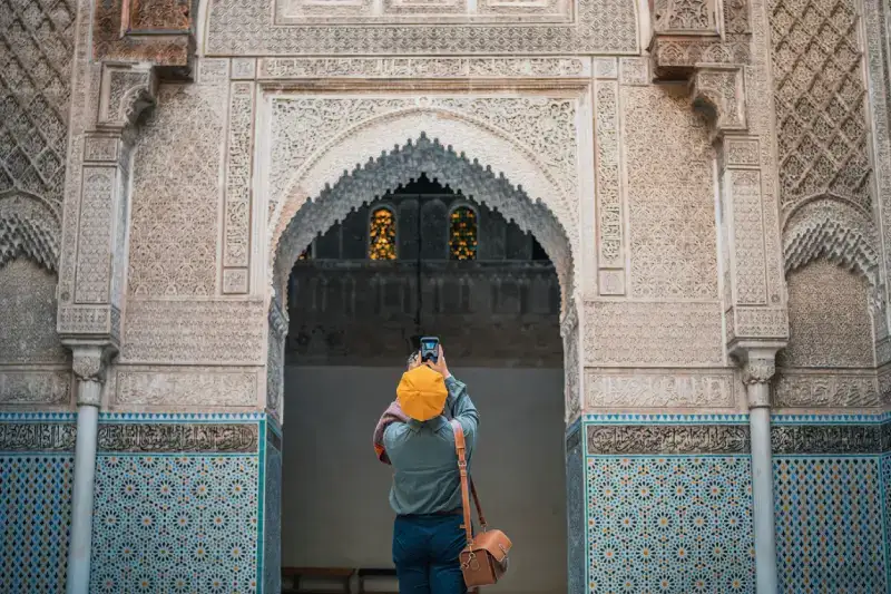 Turista donna fotografa e ammira la moschea di Fez Bou Inania Madrasa, Viaggio in Marocco