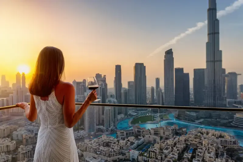 Una donna di lusso si gode la vista del tramonto dietro lo skyline di Dubai, Cose da fare a Dubai