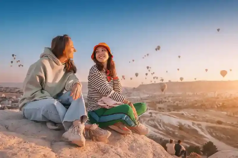 Amiche sedute su un punto panoramico in cima a una scogliera in Cappadocia, Cappadocia turchia