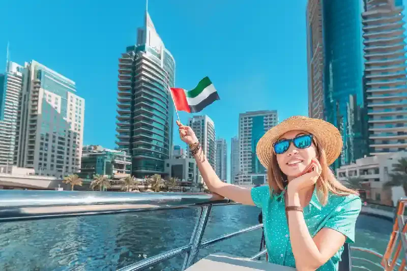 Ragazza asiatica che sventola la bandiera degli Emirati Arabi Uniti, Temperature a Dubai