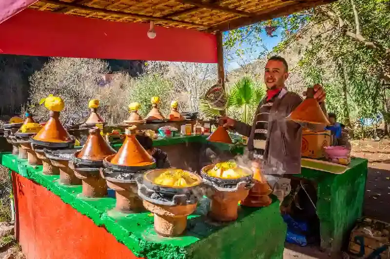 Giovane venditore che cucina tagine di pollo in Marocco, cosa mangiare in Marocco