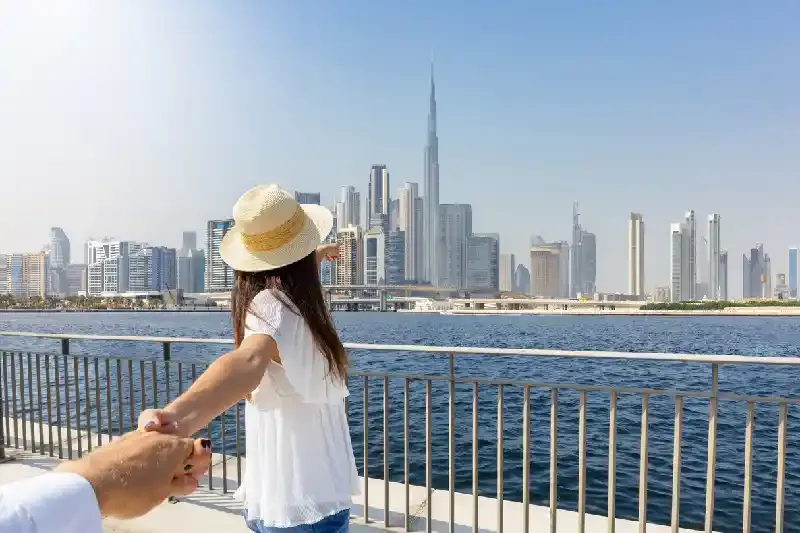 Una turista che tira la mano al suo partner, Dubai Creek