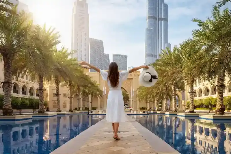 Una turista si trova in una piazza pubblica con palme nel centro di Dubai, attività a dubai