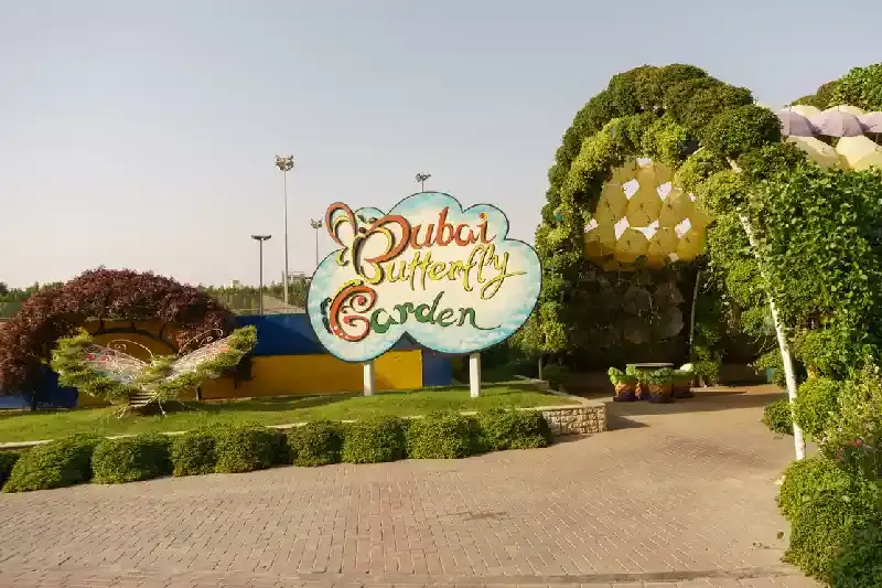 Cartello d'ingresso al Dubai Butterfly Garden con logo, giardino delle farfalle dubai