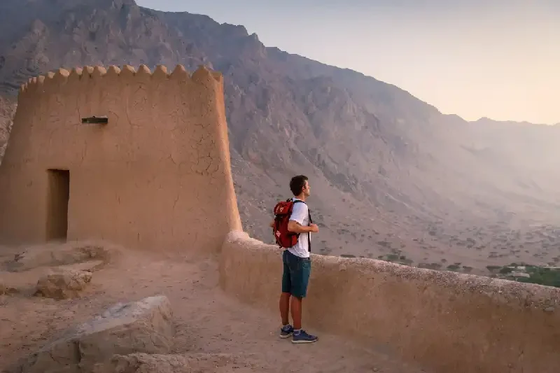 Uomo che visita il forte di Dhayah nel nord di Ras Al Khaimah, deserto di Dubai