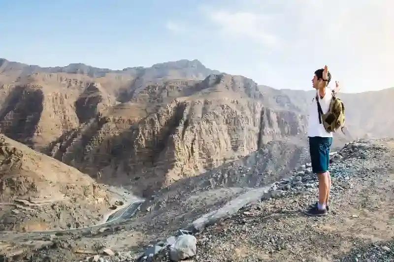 Escursionista maschio che si gode la vista sulle montagne, deserto dubai