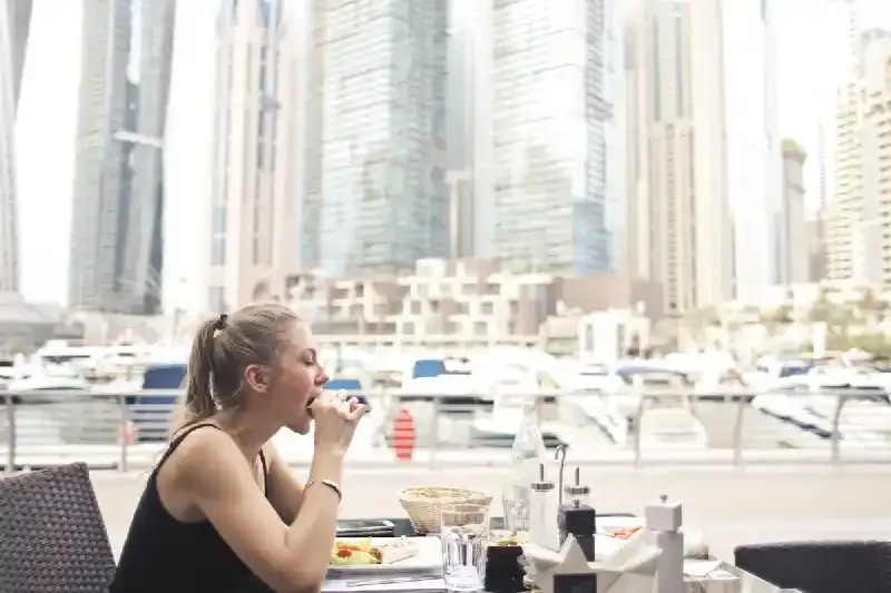 una donna asiatica mangia a Dubai, dove mangiare dubai