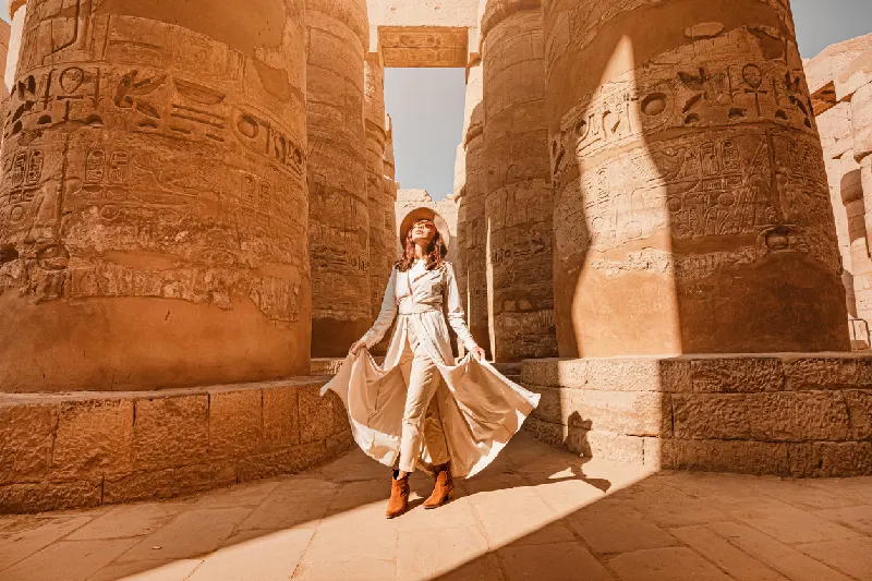 Una mujer viajera explora las ruinas del antiguo templo de Karnak en la ciudad de Luxor en Egipto.