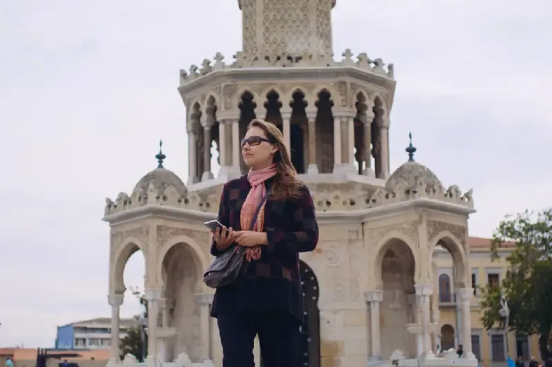 una turista davanti la torre orologio di izmir , izmir turchia