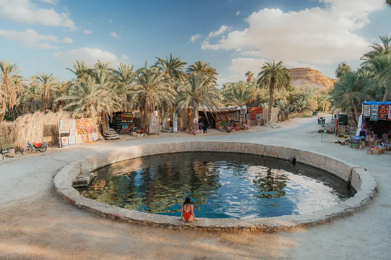 Mujer nadando en el manantial Cleopatra en el oasis de Siwa