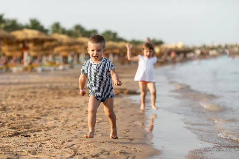 Niños hermosos divirtiéndose en una playa de Sharm el sheij. Disfrutando de un día soleado de verano, jugando y corriendo por la playa.