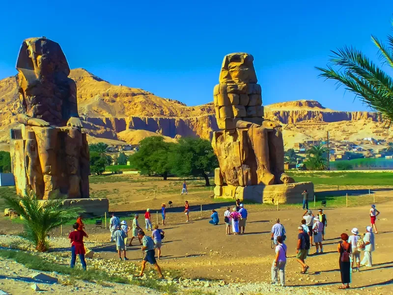 Confronto con turisti che rende l'idea dell'altezza dei Colossi di Memnone