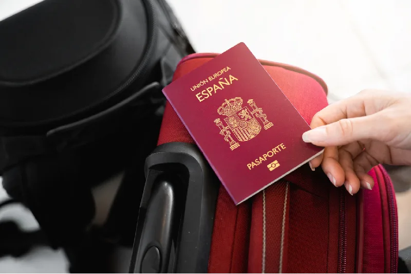 Una mano femenina irreconocible atrapa un pasaporte europeo español en el equipaje.