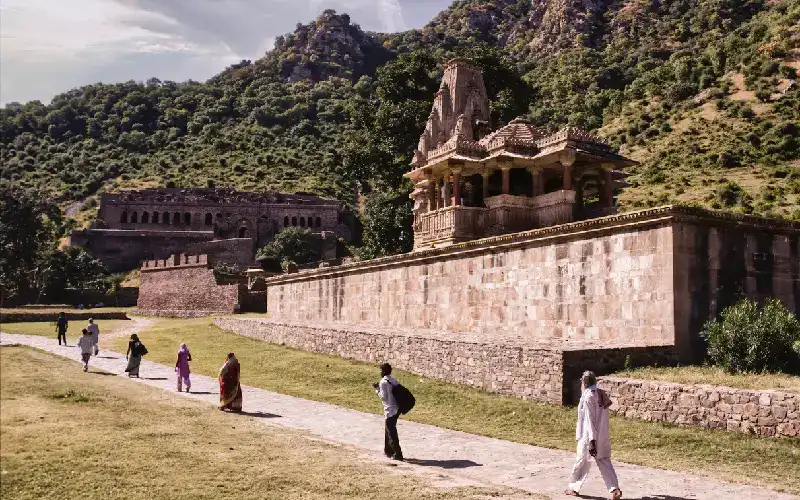 Persone che camminano in fila davanti al Bhangarh, tra le attrazioni da visitare in India