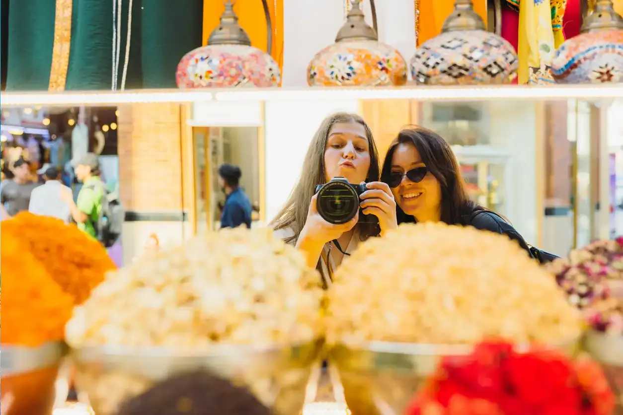 due turiste al mercato di Dubai che si divertono spendendo poco