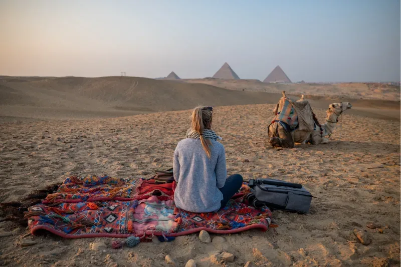 Una turista disfrutando de una visita a las pirámides de Giza en Egipto.