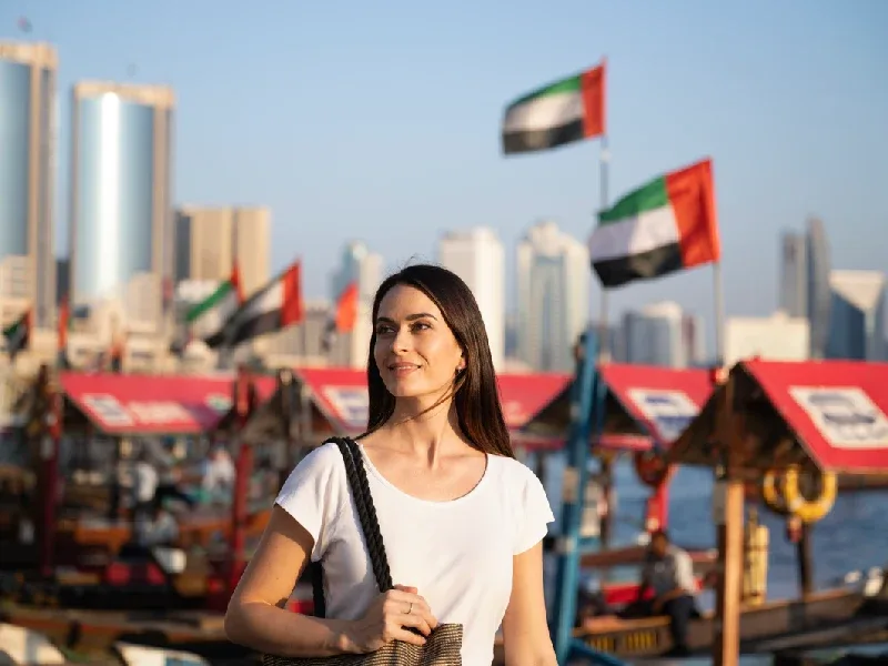 Ragazza che gira a piedi per Dubai ammirando le bellezze e risparmiando