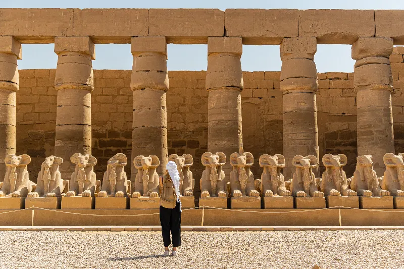 Turista paseando por el templo de Karnak en Luxor, entre la avenida de esfinges en Tebas