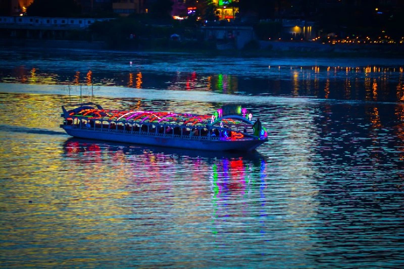 Barco turístico iluminado navegando por el Nilo de noche en Egipto