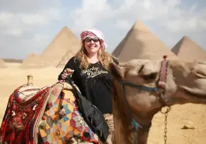 Cammellata alle Piramidi di Giza, una donna dietro un gruppo dei cammelli