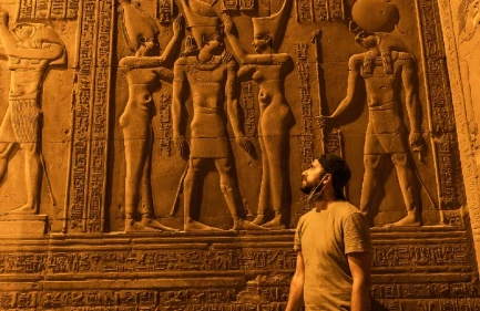 Escursione al Cairo da Luxor in Aereo, un uomo accanto al muro del tempio
