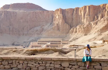 Escursione Tempio di Habu e Tombe dei Nobili, Una donna siede davanti al tempio hatshepsut