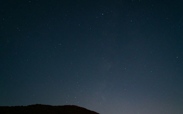 un ragazzo è in piedi accanto a un telescopio.