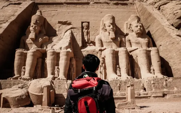 un uomo davanti il tempio di abu simbel ad assuan , egitto a dicembre