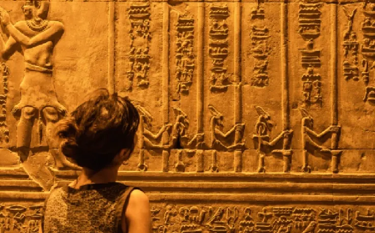 Faraone egiziano nomi, una dona davanti al muro  con disegni faraonici dentro un tempio