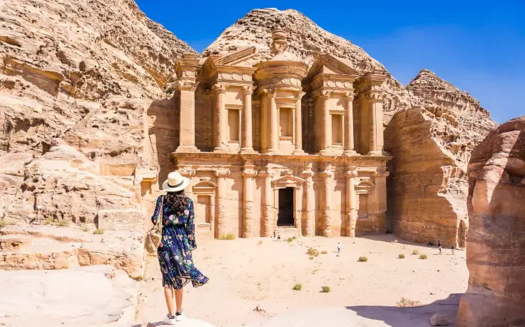 Giordania cosa visitare, Una donna indossa un vestito blu davanti a petra