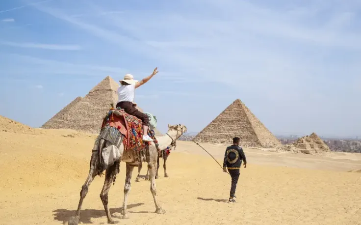 una donna cavalca un cammello a giza, Egitto posti da visitare