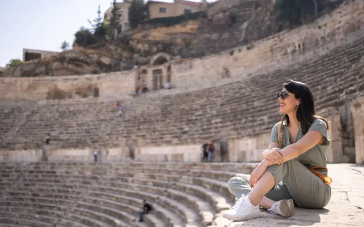 turista davanti all'anfiteatro romano di amman, visto per la giordania