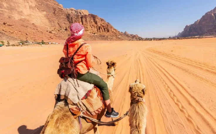 Deserto Wadi Rum, una donna a dorso sul cammello