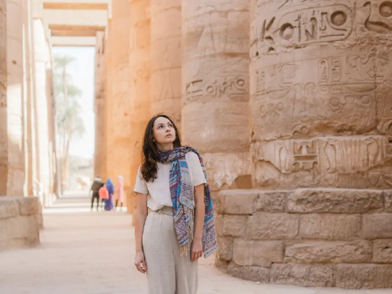 Mujer caminando en el antiguo templo egipcio de Luxor