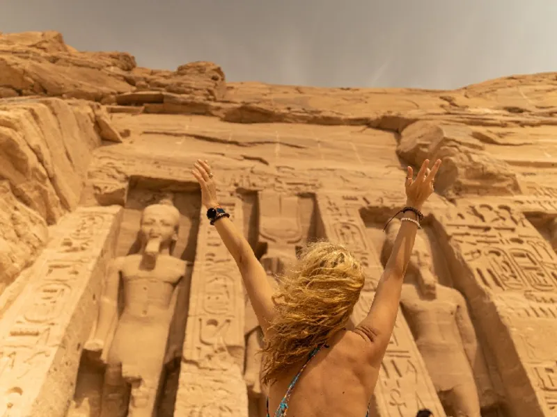 Mujer de pie frente al templo de Hathor y Nefertari, en Abu Simbel, Egipto